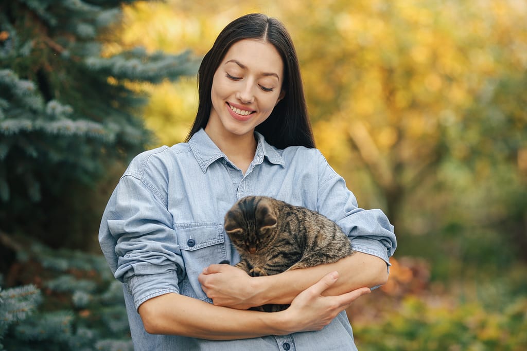 Girl in a blue shirt standing on trees background