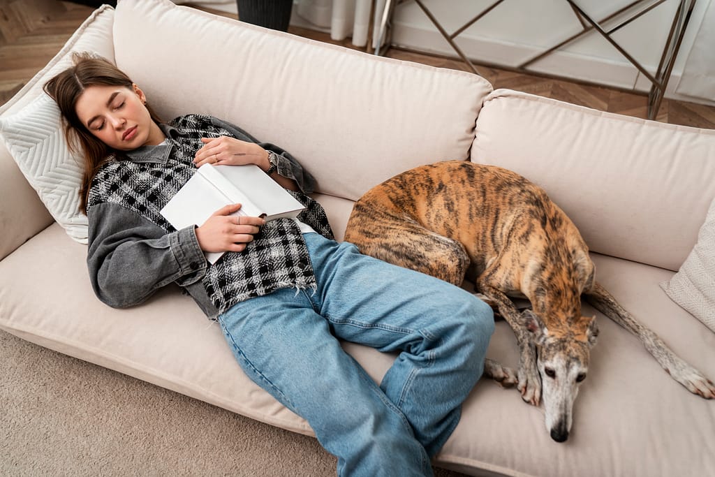 high-angle-woman-dog-sleeping-couch